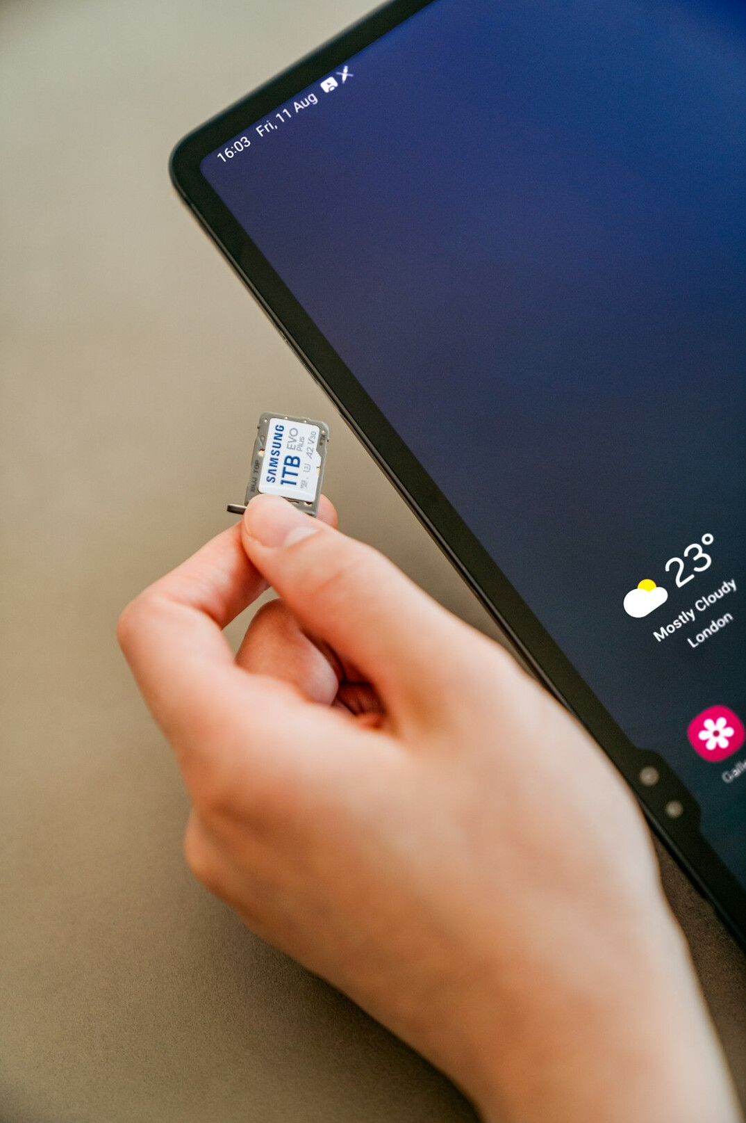 Person verifying identity with fingerprint authentication on a tablet