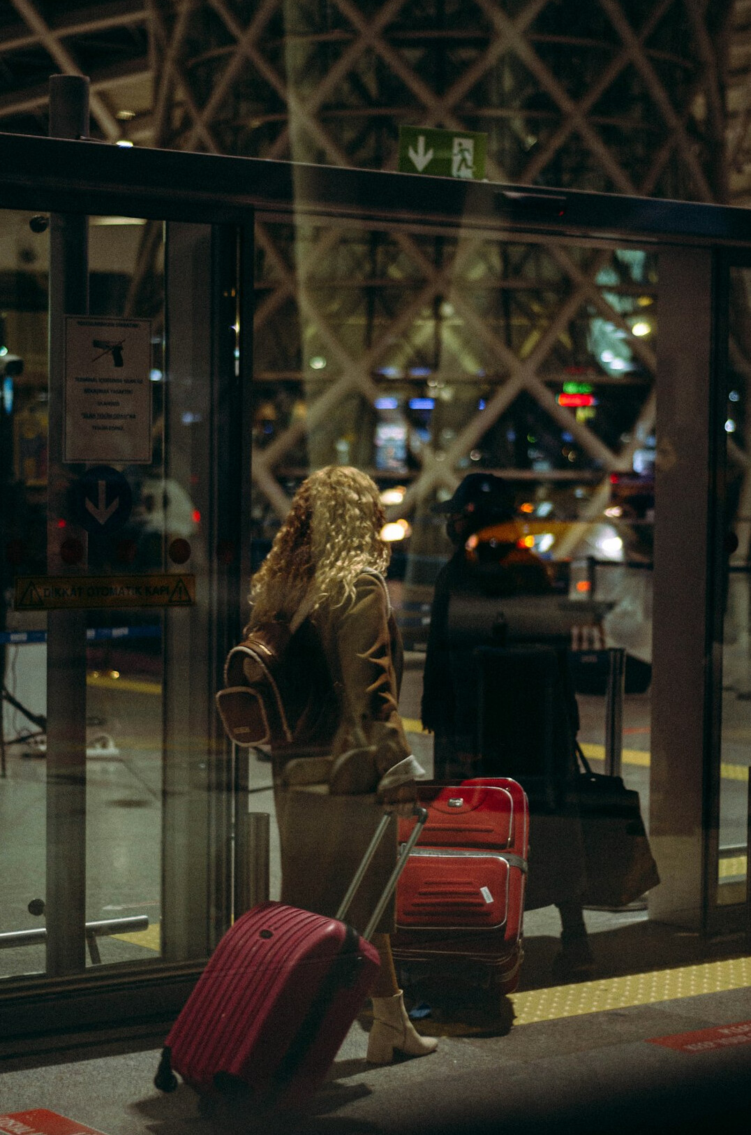 Traveler with luggage checking her phone at an airport terminal